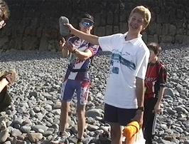 Ryan sees how long he can hold the stone in the air on Clovelly Beach